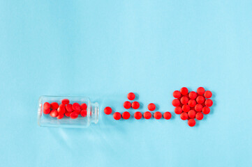 Red pills scattered bubble on a blue background in the form of a cardiogram and a heart with place for text. medicine concept