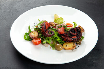 Salad with octopus and new potatoes in a plate.