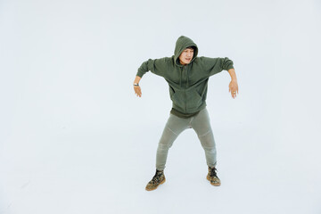 A man is performing a graceful dance in a white studio, performer masculine is a performance dancer, sportswear movement posing.