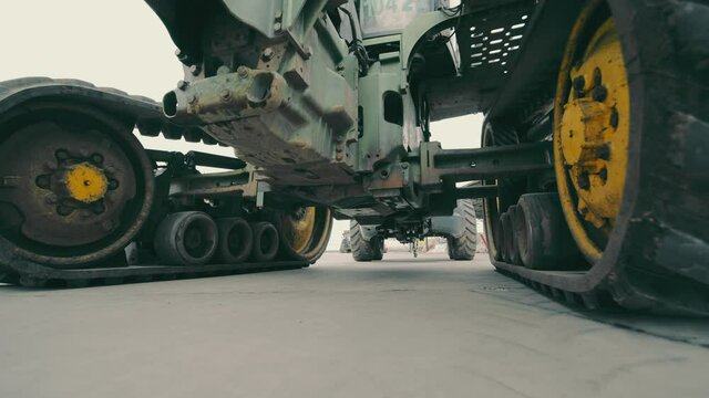 Tractor wheels and transmission operation. View of the tractor from below. Repair of large dimensional equipment.
