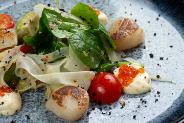 Fried scallops with herbs and red caviar.