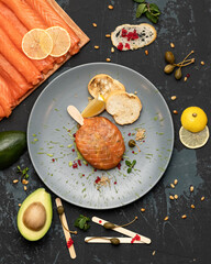 Exotic red fish dish on stick. Flat lay. Unusual appetizer with sturgeon fish, garnished with...