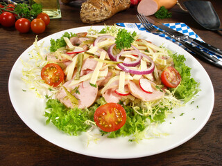 Wurstsalat mit Fleischwurst, Käse, Tomaten und Zwiebeln auf Salat
