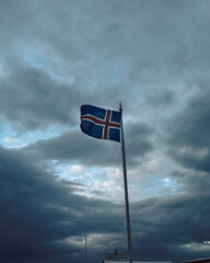 Naklejka premium Icelandic flag in a dark cloudy day in Iceland. 