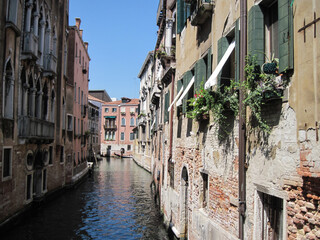 Fototapeta na wymiar Scenic Venetian cityscape with narrow canal on a sunny summer day.