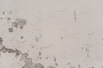 White wall with dampness in the paint and cracks. Textured background.