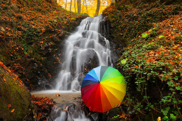 It's autumn time. Beautiful waterfall streams and colorful leaves.	