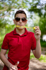 Teenager boy  with soap bubbles in the park