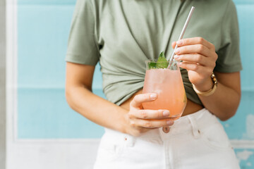 Fresh and iced summer cocktail with grapefruit, tequila and ice in female hands