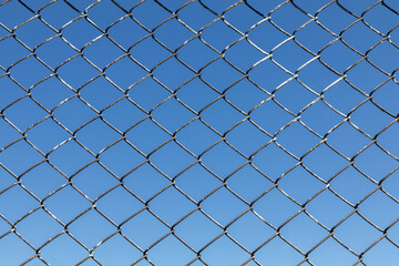 Fototapeta premium Metal mesh on a blue sky background