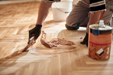 Repairman restoring old parquet hardwood floor. - obrazy, fototapety, plakaty
