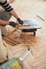 Repairman restoring old parquet hardwood floor.