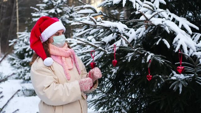 A woman decorates a Christmas tree for the New Year during the coronavirus epidemic and isolation