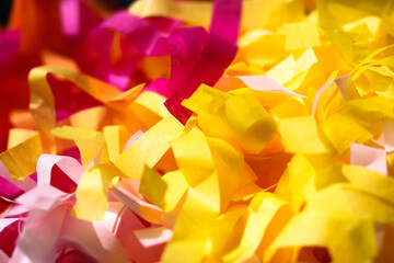 Multicolored tassel yellow, pink paper garland close-up. Festive background.