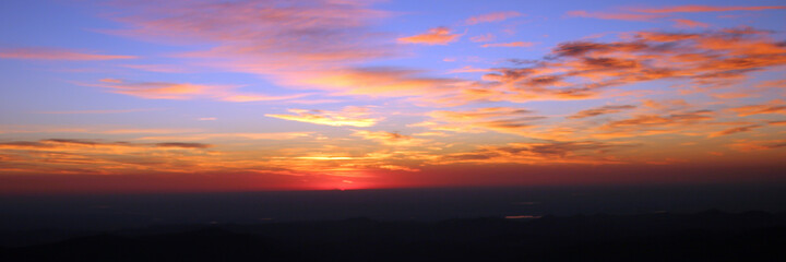 Mt. Evans Sunrise - Bright red-orange sunrise with scattered clouds in Clear Creek County, viewed from Mt. Evans, Colorado