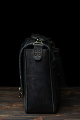 Retro style dark leather messenger bag with rivet straps.