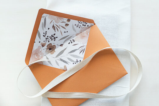 Floral lined envelope with a ribbon on a table