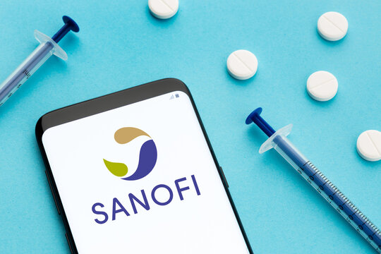 Galicia, Spain; June 8, 2020 : Smart phone showing Sanofi logo on screen and pills and syringe on blue background