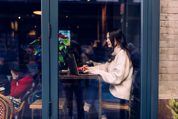Concentrated on screen of laptop lady working remotely in cafe