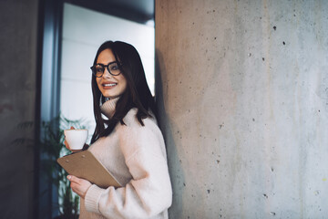Obraz premium Cheerful woman with clipboard and cup of coffee