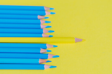 yellow pencil among blue. The concept of leader in the team
