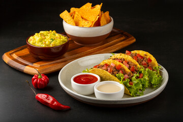 Mexican tacos with lettuce, beef and tomatoes.