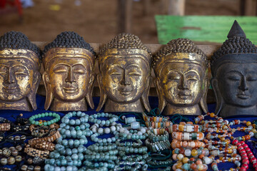 Handmade image of Buddha face and other souvenir in a tourist stall on street market near Inle Lake in Burma, Myanmar