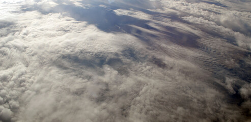 Aerial view of clouds and sky. Bird eye view from airplane window. Clouds panorama from airplane.