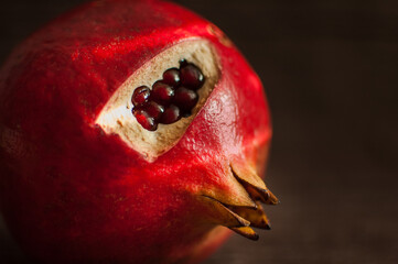 Juicy garnet, ripe pomegranate fruit on wooden background.