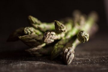 Bunch of fresh green asparagus on dark wooden table, healthy eating, seasonal products