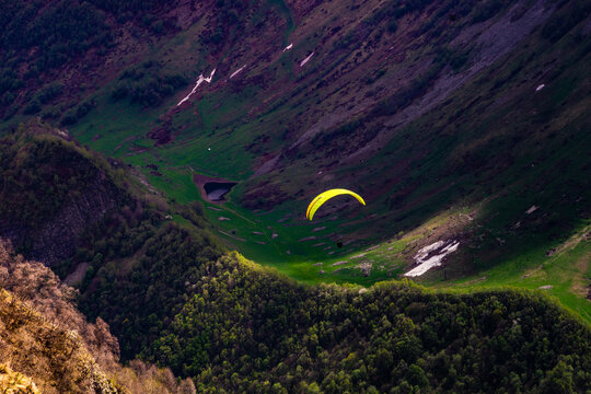 Paraglider flying over Caucasus mountains, Gudauri, Georgia