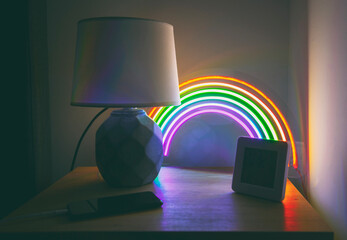 Glowing led neon rainbow on the side table in the evening