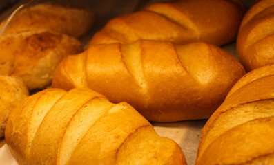 Fresh juicy bread from the oven. White flour bread in the store - photo. Unhealthy but delicious pastries. 