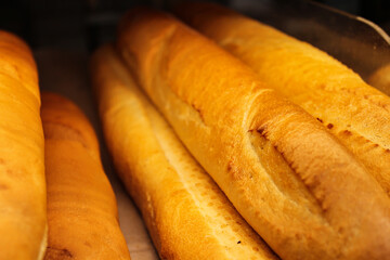 Fresh juicy bread from the oven. White flour bread in the store - photo. Unhealthy but delicious pastries. 