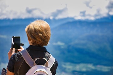 Donna che scatta un selfie  foto in montagna in Trentino panorama