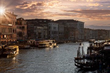 Venice Canals and gondolas near Rialto Bridge and Saint Marco square at sunset.