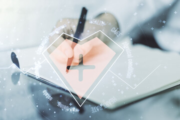 Creative concept of heart pulse illustration and man hand writing in notebook on background....