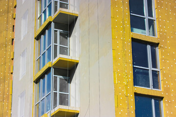 Warming of a multi-story residential building facade with a mineral, rock wool.