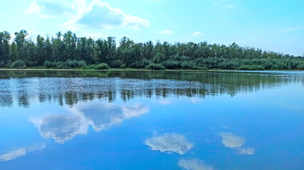Landscape with river in spring. Trees are reflected in water of river