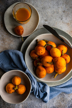 Overhead view of loquat fruits and fruit juice on a plate