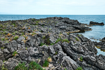 View of the gulf of Giardini Naxos with solidified volcanic lava. Beauty in Sicily as a tourist attraction. Season on mediterranean sea. Ionian sea.