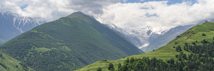 Fototapeta premium Fantastic view of mountains in North Ossetia, Alania with cloudy sky. Concept of travel the world. Russia. Wide banner