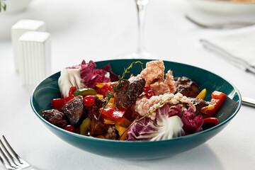 grilled liver with vegetables, fried veal liver with stewed vegetables, fresh lettuce and berries, close-up light background