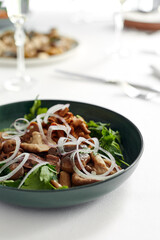 Mushrooms with onions and herbs, assorted pickled mushrooms in a plate on a light background, marinated mushrooms with fresh herbs and onions.