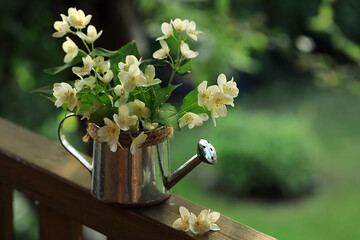 A bouquet of white blooming flowers in a metal garden watering can.