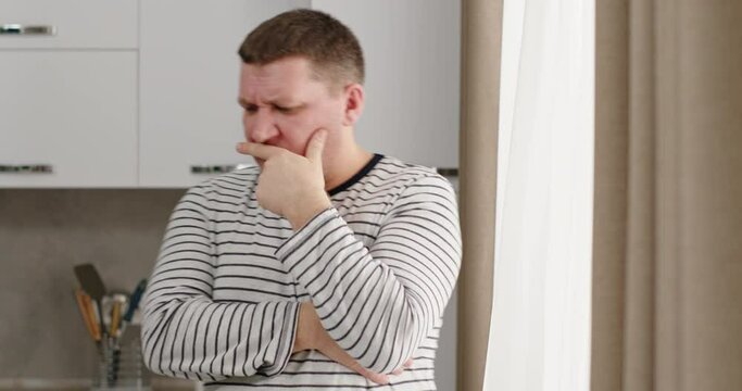 Adult man thinking in kitchen at home