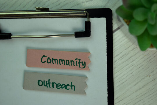 Community Outreach Write On Sticky Notes Isolated On Wooden Table.