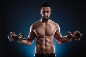 Fototapeta na wymiar Powerful muscular man lifting weights. Beautiful masculine bearded young hipster man holding dumbbells.
