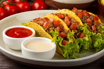 Mexican tacos with lettuce, beef and tomatoes.
