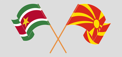 Crossed and waving flags of Suriname and North Macedonia
